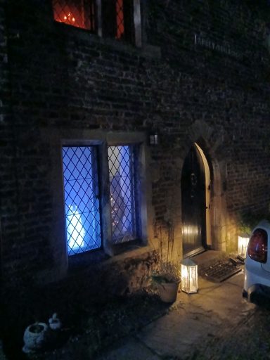 A stone building with blue-lit windows and lanterns at the entrance.